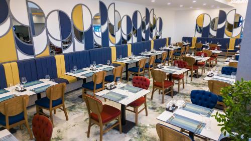 a dining room with tables and chairs and mirrors at Saint Star Kemer - Adult Only in Kemer