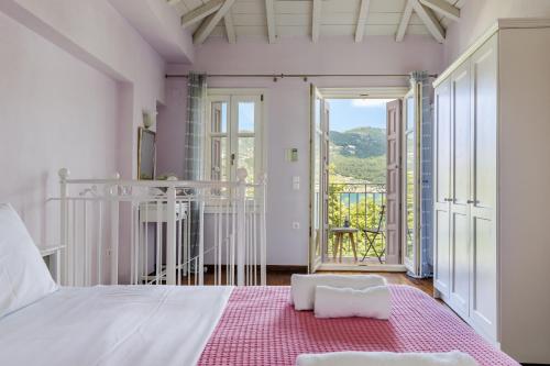 1 dormitorio con cama blanca y balcón en Sentefi Maisonette, en Skopelos Town