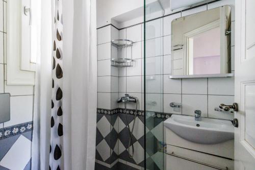 y baño con lavabo y espejo. en Sentefi Maisonette, en Skopelos Town