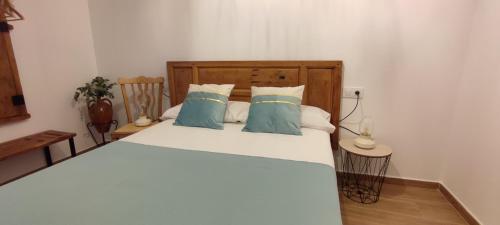 a bedroom with a large white bed with blue pillows at El Cantón in Bogarra