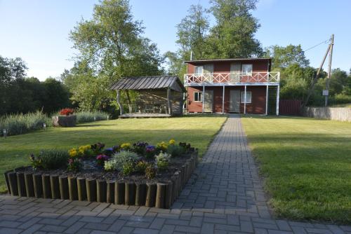 a house with a garden with flowers in a yard at Šušvė in Plinkaigalis