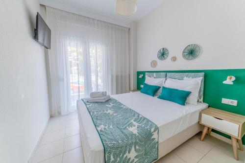 een slaapkamer met een groot bed met een groen hoofdeinde bij Evangelia Rooms & Apartments - A in Asprovalta
