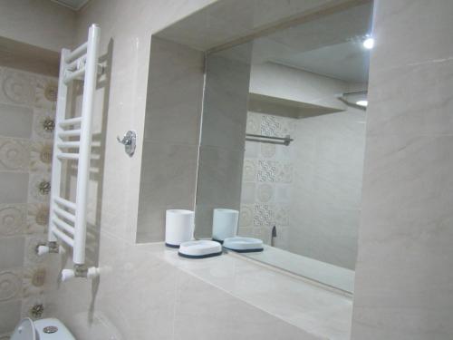 a white bathroom with a mirror and a sink at Apartment 19 in Kutaisi