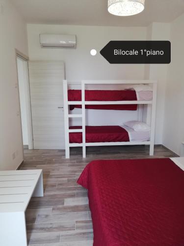 a bedroom with two bunk beds and a red blanket at Fascino del Cilento - Appartamenti in Caprioli