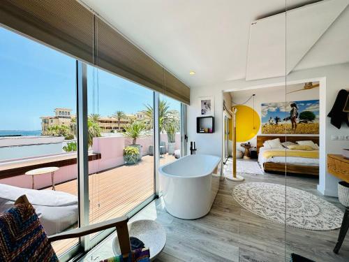 - un salon avec une baignoire et une vue sur l'océan dans l'établissement Casa Color, à Corralejo