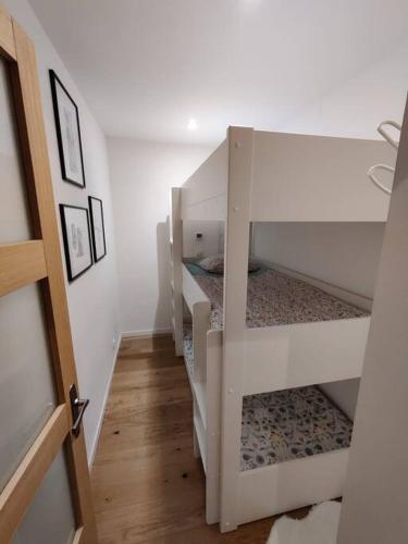un couloir avec 3 lits superposés dans une chambre dans l'établissement Appartement 65 m² proche pistes, à Bolquère-Pyrénées 2000