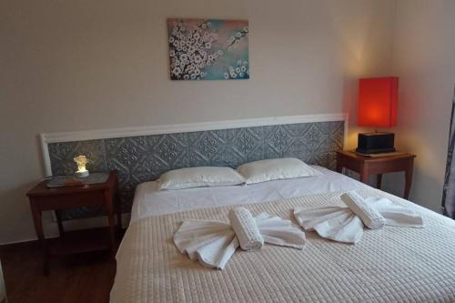 una camera da letto con un letto con asciugamani bianchi sopra di Ipsos Apartment Mari a Città di Corfù