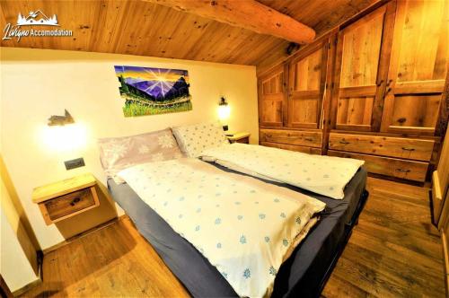 um quarto com uma cama num quarto com paredes de madeira em Chalet Heaven Mottolino em Livigno