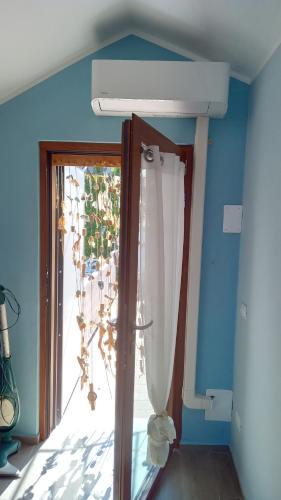 a room with a window and a door with a chandelier at Mansarda a Noli e Spotorno in Noli