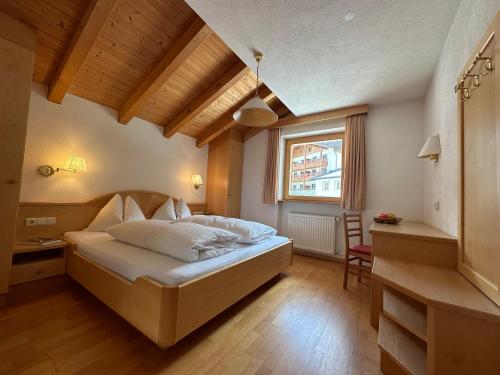 um quarto com uma cama, uma secretária e uma janela em Residence Aster em Solda