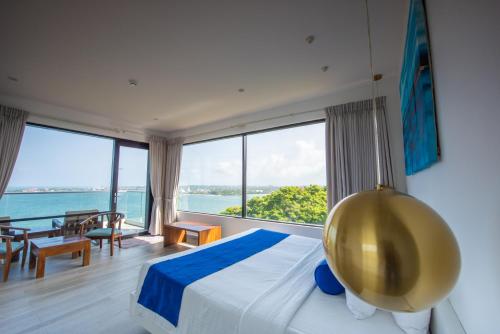 a bedroom with a large bed with a view of the ocean at Agnus Unawatuna in Unawatuna