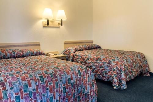 a hotel room with two beds with colorful sheets at Loyalty Inn Columbus in Brice