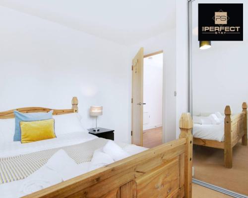 a bedroom with a wooden bed with a yellow pillow at Cosmo Modern Apartment Central By Your Perfect Stay Short lets Birmingham in Birmingham