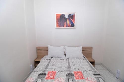 1 cama en una habitación con una foto en la pared en Къмпинг Арда 