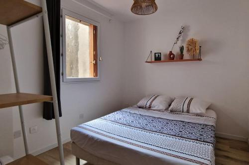 een slaapkamer met een bed in een kamer met een raam bij Appartement en bord de mer 2 in Banyuls-sur-Mer