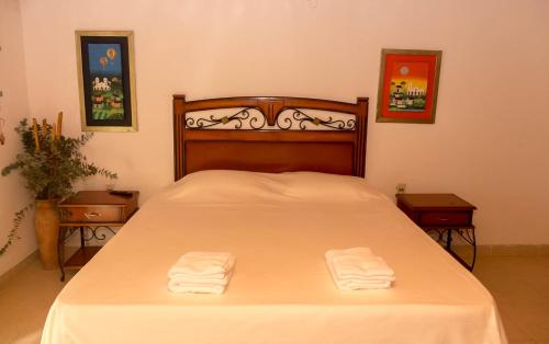 1 dormitorio con 1 cama con 2 toallas en Granja 17 de Noviembre, en Atyrá
