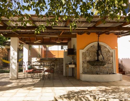 a patio with tables and chairs under a pergola at Granja 17 de Noviembre in Atyrá