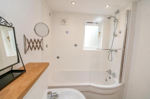 ein Bad mit einer Badewanne, einem Waschbecken und einer Dusche in der Unterkunft The Loft Cottage in Totnes