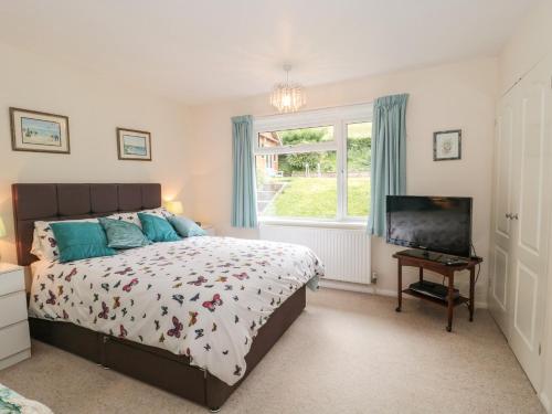 a bedroom with a bed and a television at Deepdene in Dorchester