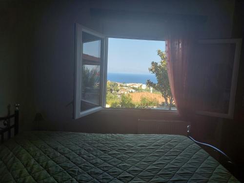 ein Schlafzimmer mit einem Bett und einem offenen Fenster in der Unterkunft Depys' View in Chios