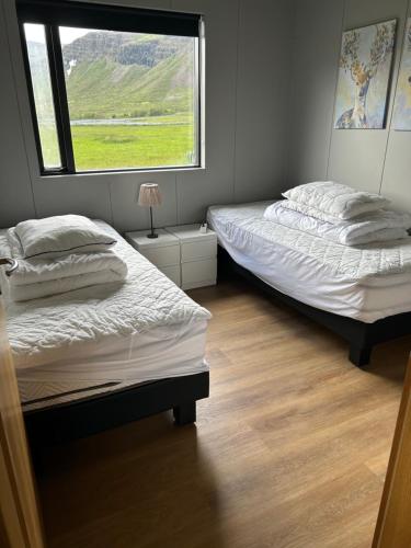 two beds in a room with a window at Bjarkarholt Guesthouse in Bjarkarholt