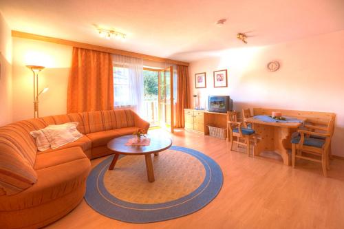 a living room with a couch and a table at Sauschneid Hof in Taxenbach