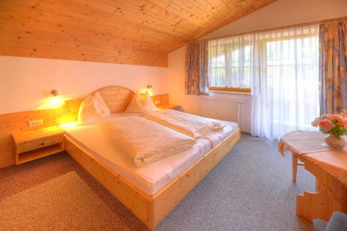Un dormitorio con una cama grande y una ventana en Sauschneid Hof, en Taxenbach