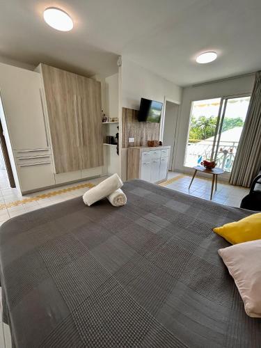 a large bed with a towel on it in a bedroom at Studio avec vue mer dans la résidence Manganao in Saint-François
