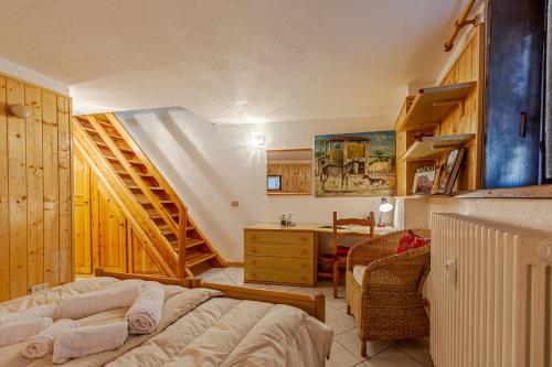 una camera con letto, scrivania e scala di Casa Alice a La Thuile