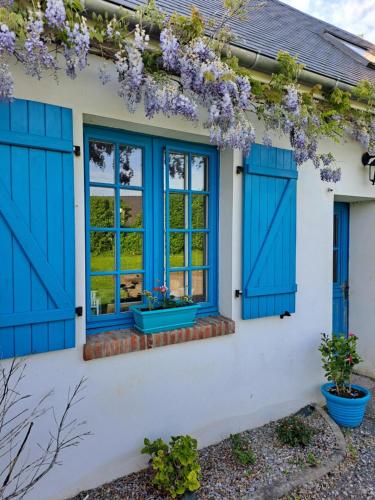 a house with blue shutters and a window at Les suites d'Élise - Suite Louane in Grumesnil