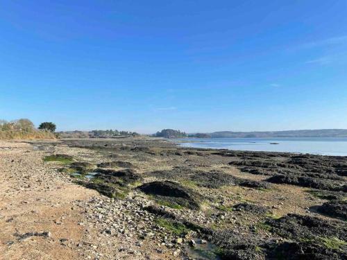 a beach with rocks and water on the shore at Chez Lorenz in Hôpital-Camfrout