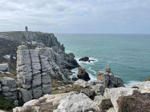a lighthouse on top of a cliff near the ocean at Chez Lorenz in Hôpital-Camfrout