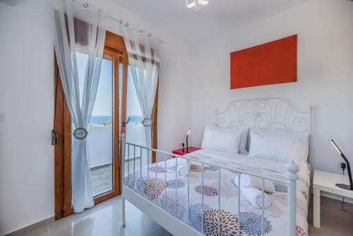 a bedroom with a bed and a balcony at Ciel Blue Villas in Kiotari