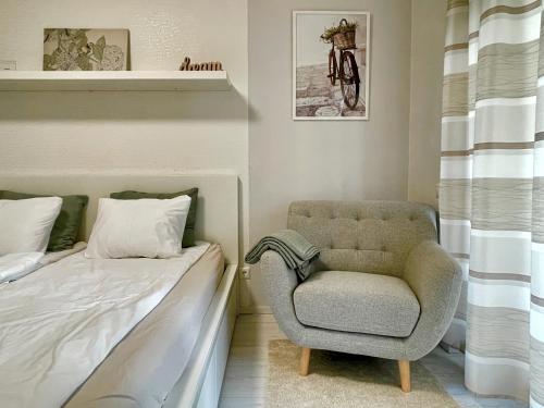 a bedroom with a chair next to a bed at Marina Panorama Apartment & Garage in Budapest