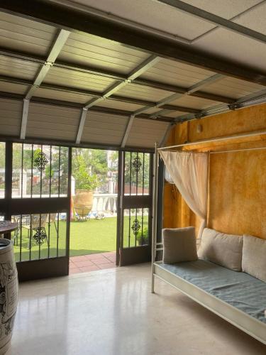 a bedroom with a bed in a room with windows at Casa Los Encinares in Córdoba