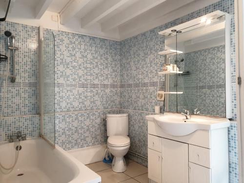 La salle de bains est pourvue d'un lavabo, de toilettes et d'une baignoire. dans l'établissement Maison 150m2 jardin à louer en entier, Bordeaux centre Chartrons, 3 Chambres 3 Salles de bains 1 canapé-lit llllnuméro de téléphone dans l'annonce si questionlll, à Bordeaux