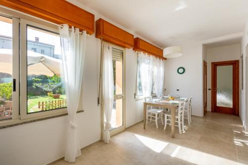 een woonkamer met een tafel en een raam bij Il Giardino di Elvira in Carbonia