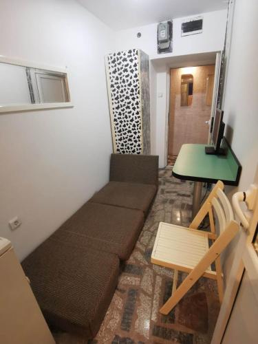uma pequena sala de estar com um sofá e uma mesa em EXIT apartman em Novi Sad