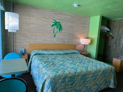 a hotel room with a bed and a table and a desk at Caribbean Motel in Wildwood Crest