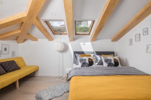 een slaapkamer met 2 bedden en een gele bank bij CABALLERO in Opatija
