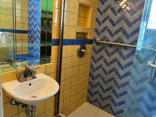 W łazience znajduje się umywalka i lustro. w obiekcie Caribbean Motel w mieście Wildwood Crest