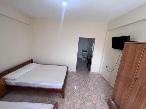 a bedroom with a bed and a tv in it at Dhoma Plazhi Husi in Borsh