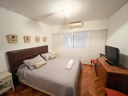 a bedroom with a bed and a television in it at Coqueto departamento en Recoleta in Buenos Aires
