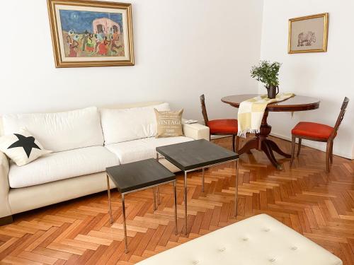 ein Wohnzimmer mit einem weißen Sofa und einem Tisch in der Unterkunft Coqueto departamento en Recoleta in Buenos Aires