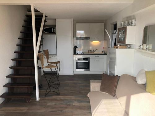 un salon avec un canapé et une cuisine dans l'établissement T2/T3 duplex à Port Frejus proche de la mer, à Fréjus