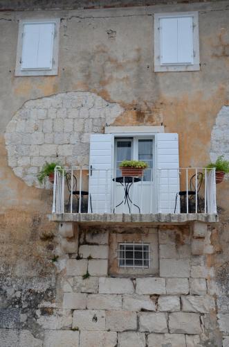 a balcony with a table and chairs on a building at Castel Nonna Franka in Sutivan