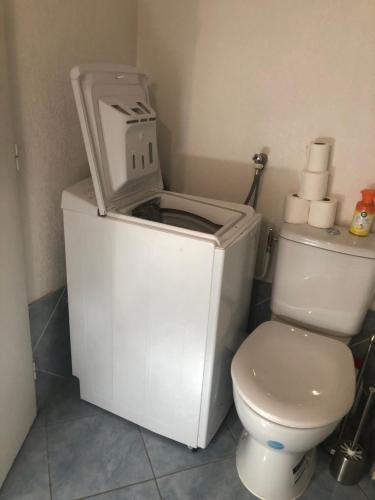 a white toilet in a bathroom with a toilet paper dispenser at T2/T3 duplex à Port Frejus proche de la mer in Fréjus