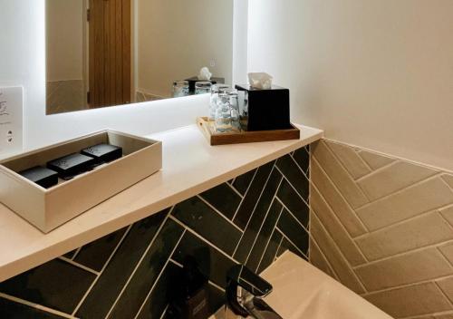 uma casa de banho com um balcão com um lavatório e um espelho em Rooms at Haslar Marina em Gosport