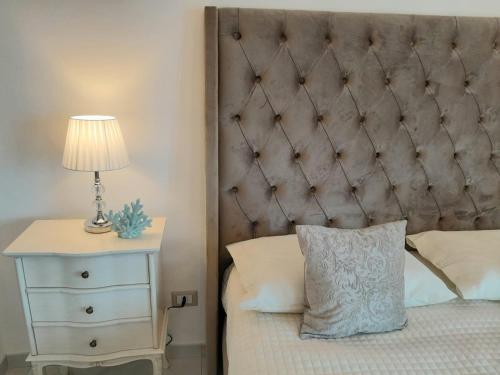 a bed with a headboard and a night stand with a lamp at La Vigna del Vento in Casola di Napoli