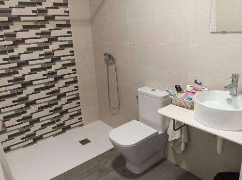 a bathroom with a toilet and a sink and a shower at PENSION IRATI in Rincón de Soto